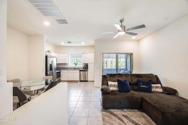 living room with a ceiling fan, recessed lighting, visible vents, and light tile patterned floors