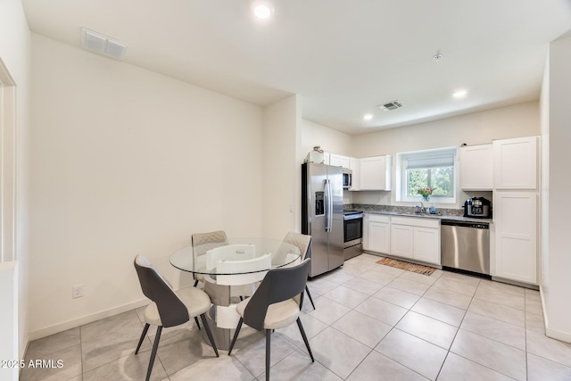 kitchen featuring light tile patterned floors, visible vents, appliances with stainless steel finishes, and white cabinets