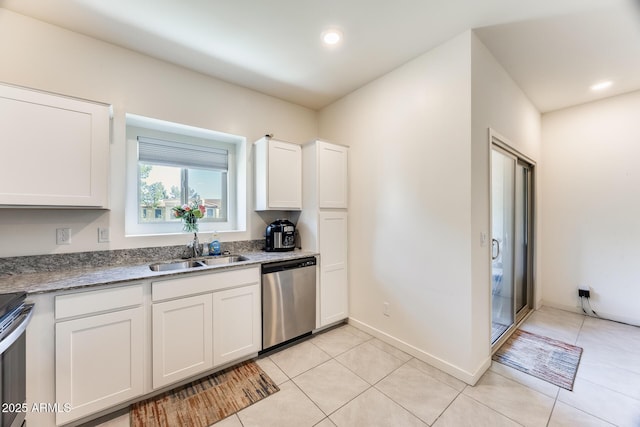 kitchen featuring dishwasher, light tile patterned floors, a sink, and white cabinets