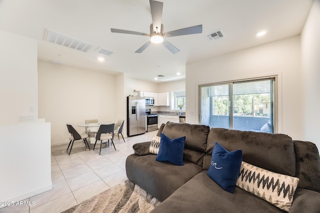 living area with light tile patterned floors, ceiling fan, and visible vents