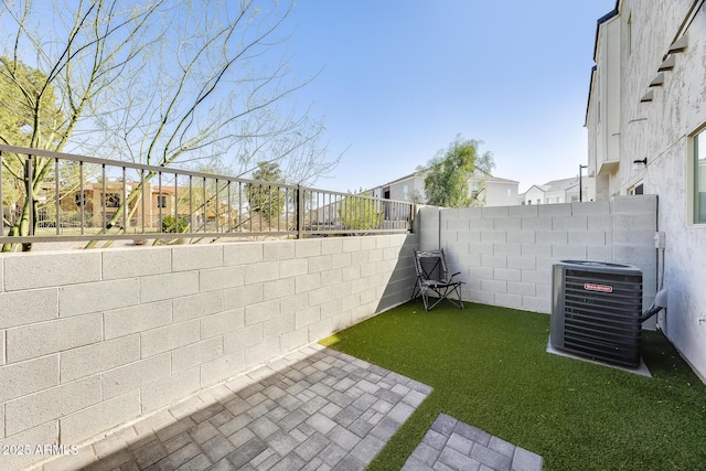 view of yard with a residential view, central AC, and a fenced backyard