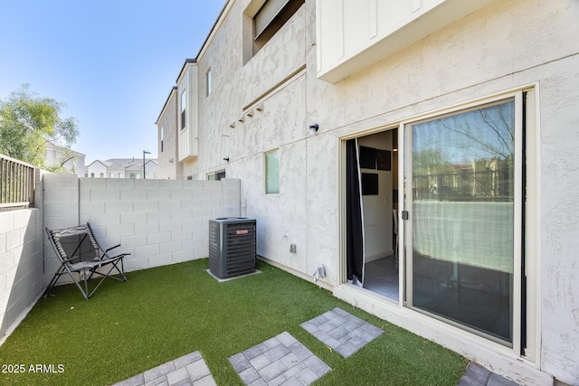 view of yard featuring fence and central AC