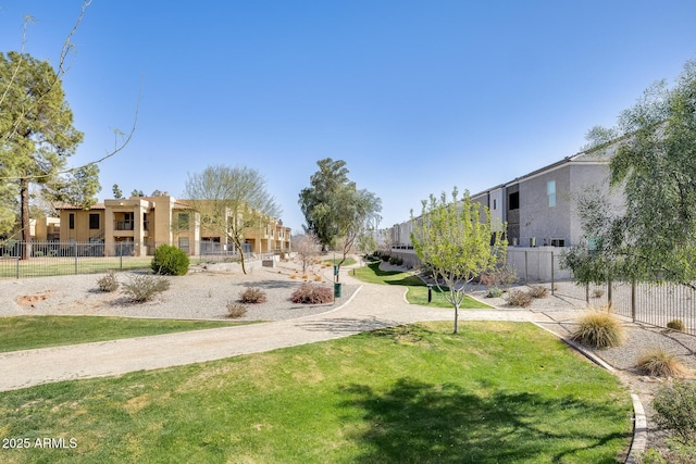 view of community with fence and a lawn