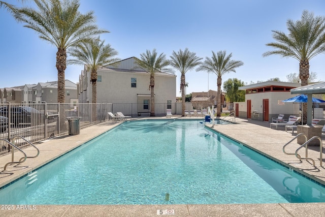 pool with a residential view, a patio, and fence