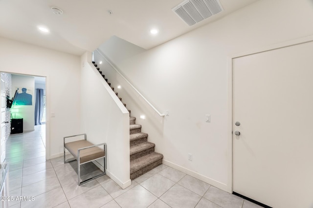 entrance foyer with light tile patterned floors, stairway, visible vents, and baseboards