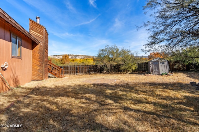 view of yard featuring a mountain view and a storage shed