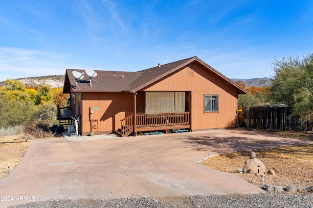 view of front of property with a deck with mountain view