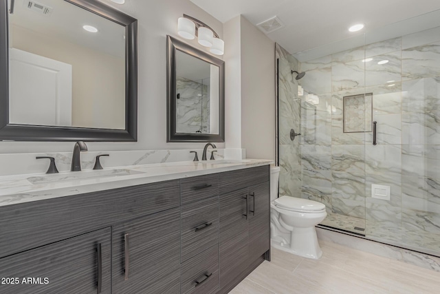 bathroom featuring toilet, vanity, and a shower with shower door