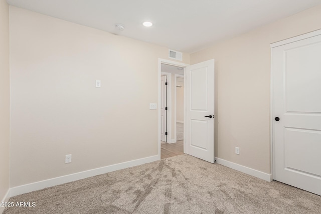 unfurnished bedroom featuring light colored carpet and a closet