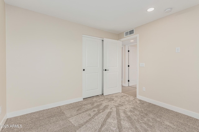 unfurnished bedroom featuring a closet and light carpet