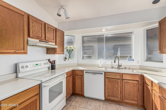 8566 N 108th Ln, Peoria, AZ 85345 - kitchen featuring white appliances, under cabinet range hood, light tile patterned floors, brown cabinetry, and light countertops