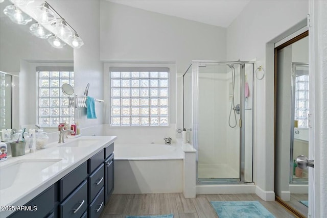 bathroom with shower with separate bathtub, lofted ceiling, a wealth of natural light, and vanity