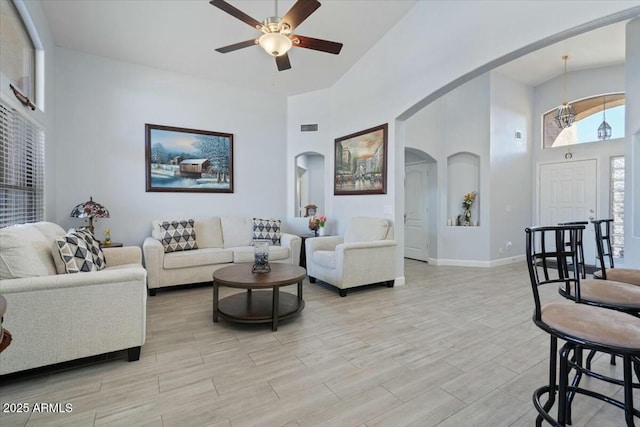 living room with a towering ceiling and ceiling fan