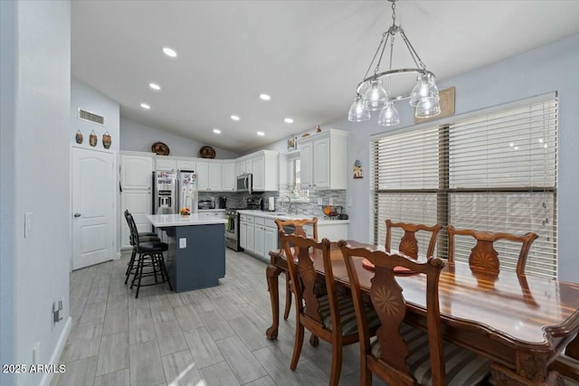 dining room featuring vaulted ceiling and sink