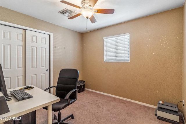 carpeted home office featuring ceiling fan