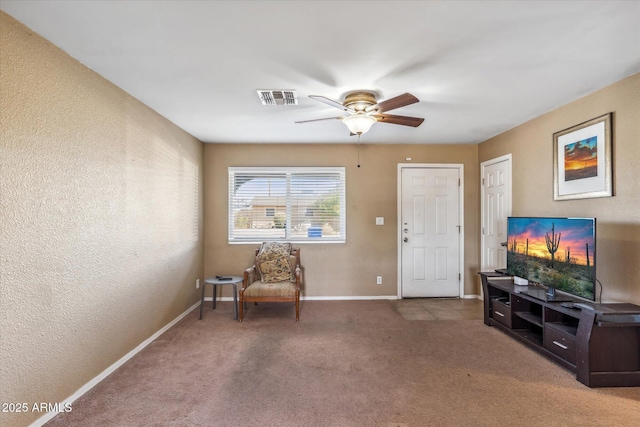 sitting room with ceiling fan and carpet