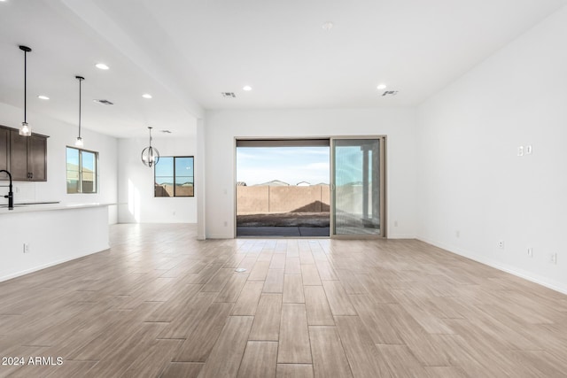 unfurnished living room featuring an inviting chandelier