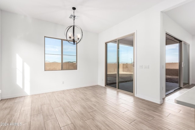 unfurnished room with a chandelier and a healthy amount of sunlight