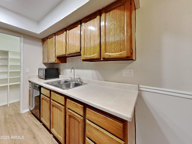 16635 N Cave Creek Rd Unit 232, Phoenix, AZ 85032 - kitchen with brown cabinetry, light wood-style floors, light countertops, a sink, and black appliances