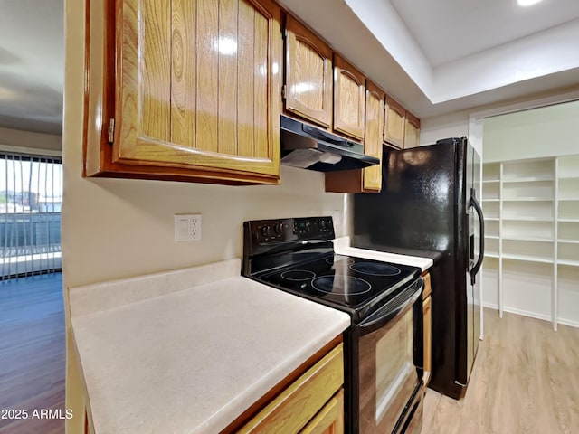 16635 N Cave Creek Rd Unit 232, Phoenix, AZ 85032 - kitchen with brown cabinetry, light countertops, under cabinet range hood, black range with electric stovetop, and light wood finished floors