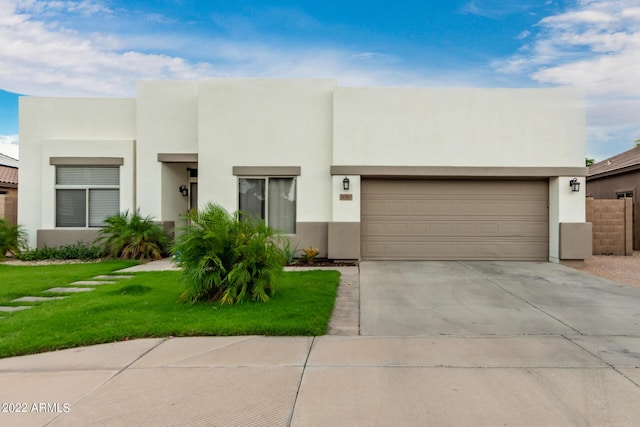 pueblo-style house featuring a front lawn