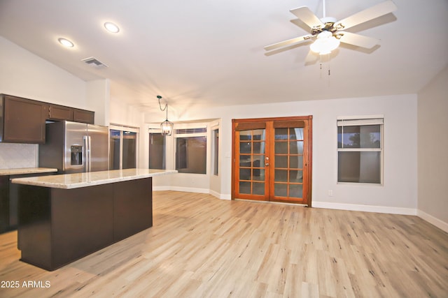 5941 W Venus Way, Chandler, AZ 85226 - kitchen featuring stainless steel refrigerator with ice dispenser, light wood-style floors, baseboards, decorative light fixtures, and a center island
