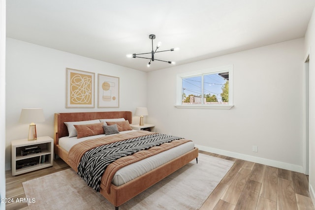 bedroom featuring a chandelier and light hardwood / wood-style flooring