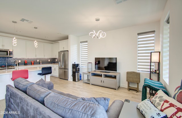 living room with light hardwood / wood-style floors and sink