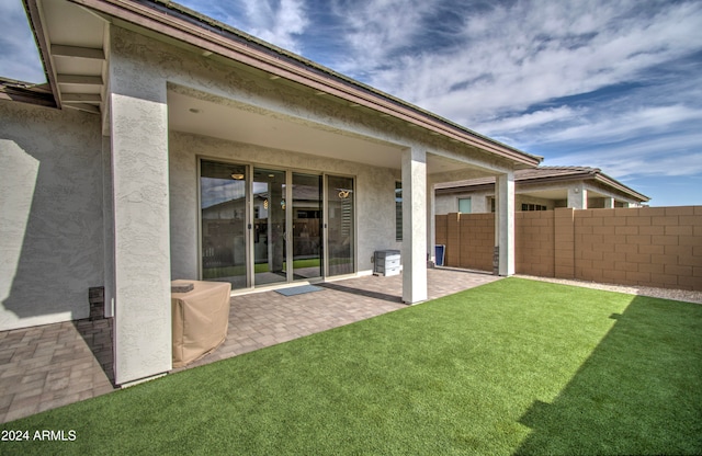 back of house featuring a lawn and a patio