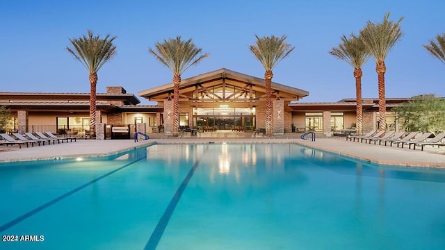 pool at dusk featuring a patio area