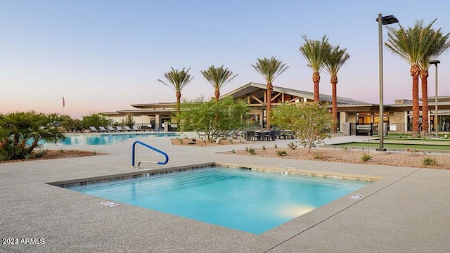 pool at dusk with a patio