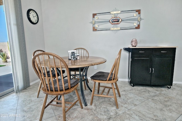 dining space featuring light tile patterned flooring and baseboards