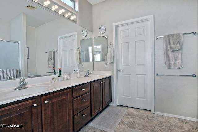 full bathroom featuring double vanity, baseboards, visible vents, and a sink