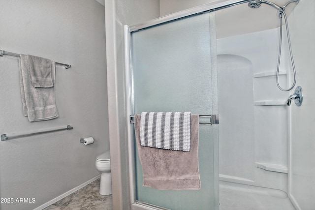 full bath featuring baseboards, toilet, and a shower stall