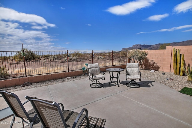 view of patio / terrace featuring a mountain view and a fenced backyard