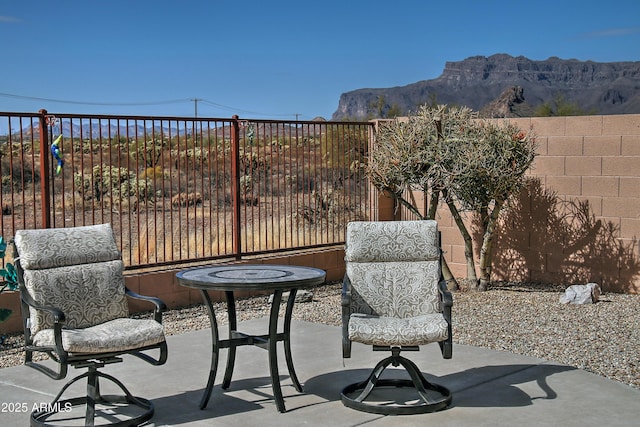 view of patio / terrace with fence and a mountain view