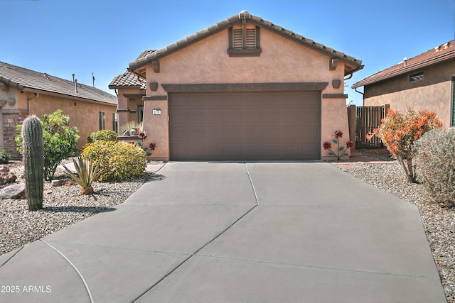 view of front facade with stucco siding, concrete driveway, an attached garage, and a tiled roof