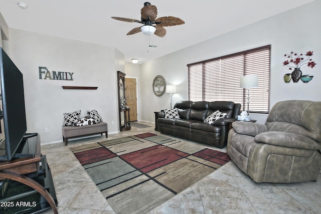 living area featuring baseboards and a ceiling fan