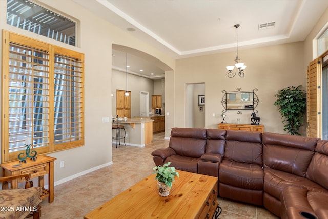 12976 W Plum Rd, Peoria, AZ 85383 - living area with light tile patterned floors, a raised ceiling, visible vents, baseboards, and arched walkways
