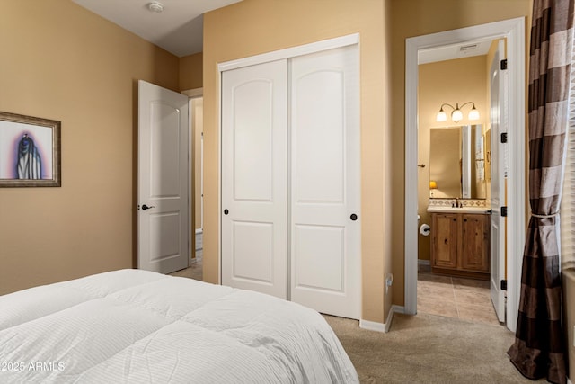 12976 W Plum Rd, Peoria, AZ 85383 - bedroom with connected bathroom, a closet, light carpet, a sink, and baseboards