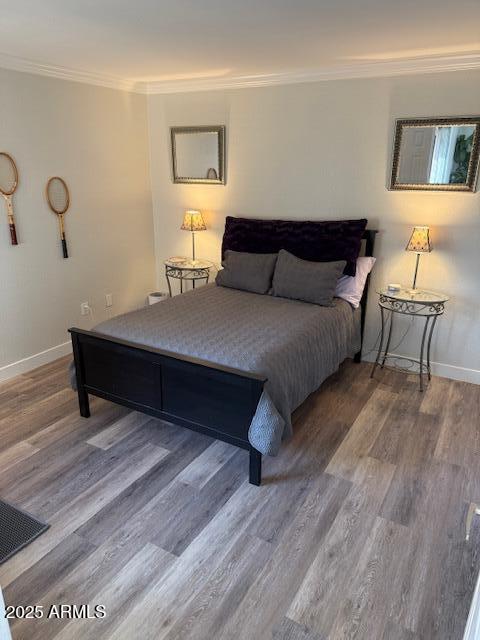 bedroom featuring hardwood / wood-style floors and crown molding