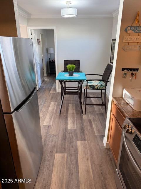 dining area featuring crown molding and light wood-type flooring