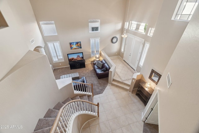 living room with a towering ceiling and light colored carpet