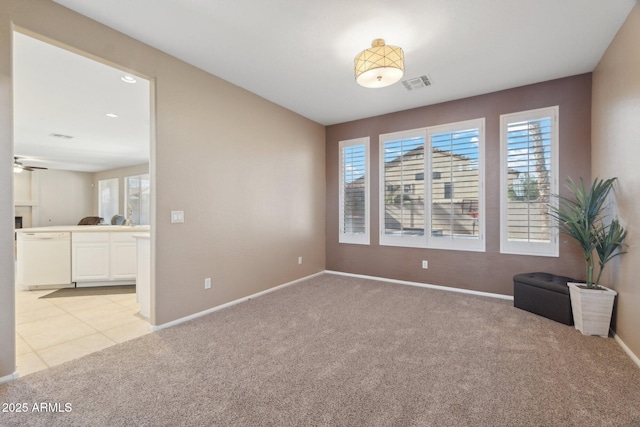 spare room with ceiling fan and light carpet