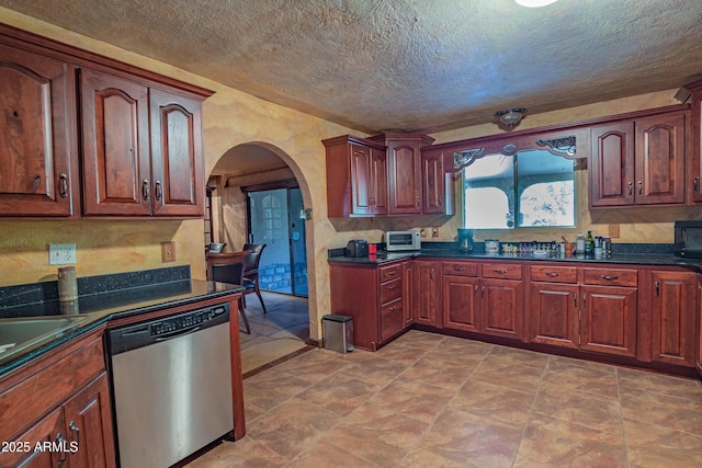 kitchen with stainless steel dishwasher and a textured ceiling