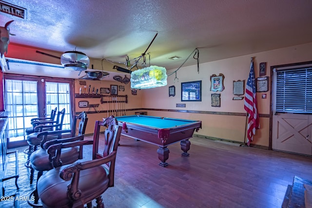 recreation room featuring hardwood / wood-style flooring, pool table, and a textured ceiling