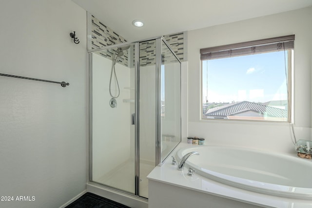 bathroom with separate shower and tub and a healthy amount of sunlight