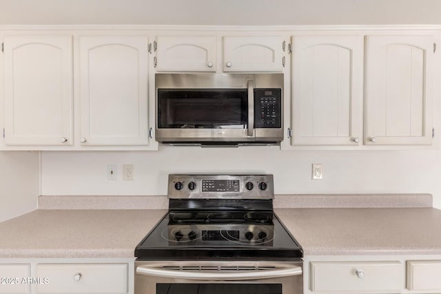 kitchen featuring light countertops, stainless steel appliances, and white cabinets