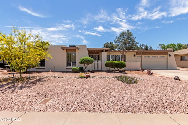 southwest-style home with an attached garage, driveway, and stucco siding