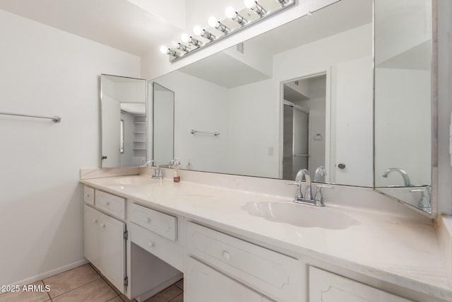 full bath featuring tile patterned flooring, a sink, a shower with shower door, and double vanity